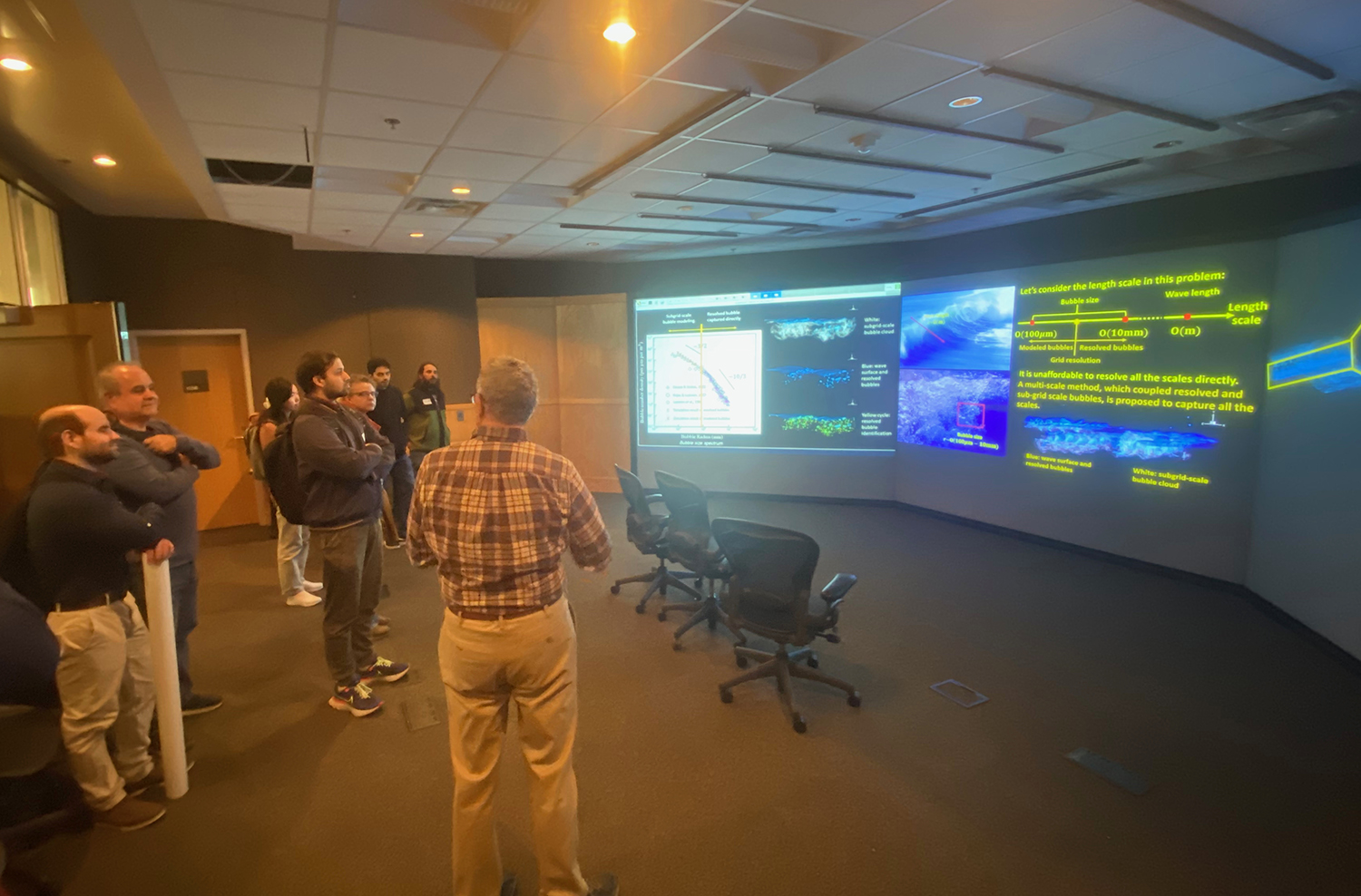 group of people watch large video screen